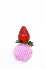 large strawberry stands on pink marshmallow on white background
