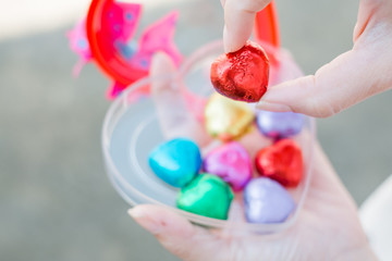 Hand of a young woman holding a chocolate heart shaped