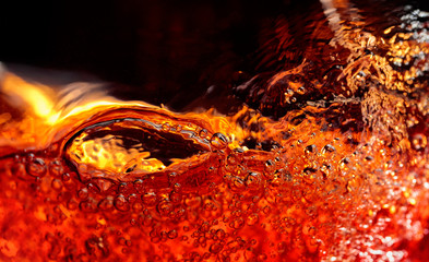 Alcoholic drink on a dark background, abstract splashing.