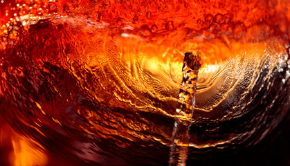 Alcoholic drink on a dark background, abstract splashing.