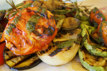 Tomato, zucchini, onions and eggplant grilled and decorated with rosemary on a plate on the table