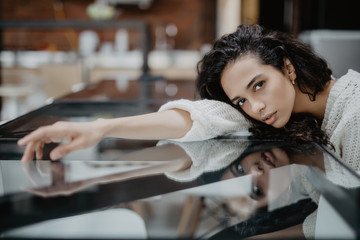 Portrait of beautiful woman leans at hands, looks exhausted after hard work