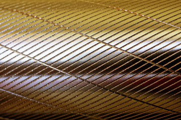 Metal round surface with longitudinal and transverse notches. Golden shade. Background and pattern