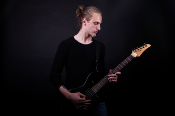 Young caucasian adult with long hair playing guitar