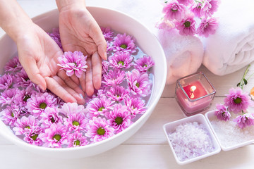 Fototapeta na wymiar Spa treatment and product for female feet and manicure nails spa with pink flower and rock stone, copy space, select focus, Thailand. Healthy Concept