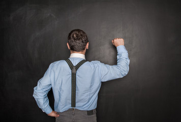 Business man knock by fist on blackboard. Opportunity concept