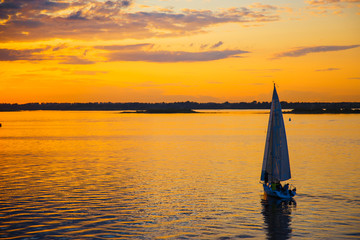 Yacht sailing against sunset. Holiday lifestyle landscape with skyline sailboat