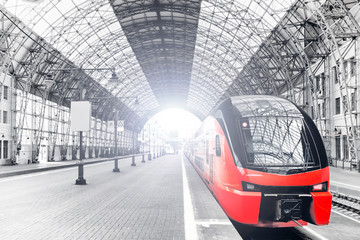 railway train station interior wide view of historical railroad transportation building in Moscow city Russia with modern train arriving to platform black and white retro stylized background © vaalaa