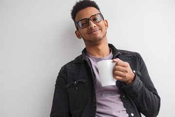 Pleased black man with hot beverage