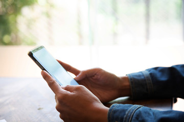 businessman hands searching for data on mock up mobile phone with at his workplace.concept