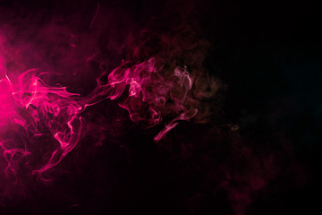 Colored background with winding clouds of smoke from patterns of different forms of pink, green and blue colors with tongues of flame on a black isolated background