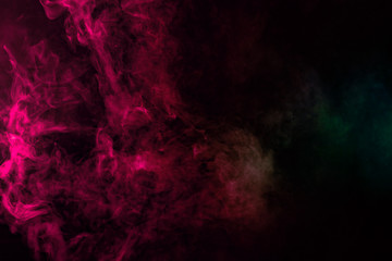 Obraz na płótnie Canvas Colored background with winding clouds of smoke from patterns of different forms of pink, green and blue colors with tongues of flame on a black isolated background
