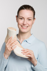 Female orthopedic shoemaker holds a handmade wooden last