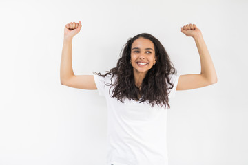 Young pretty woman with win gesture and raised hands isolated on white background