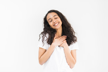 Pleased woman reclines on her hands and looking at the camera over white background