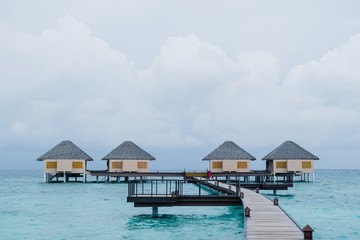 Fototapeta na wymiar Water Villas and wooden bridge at Tropical beach in the Maldives