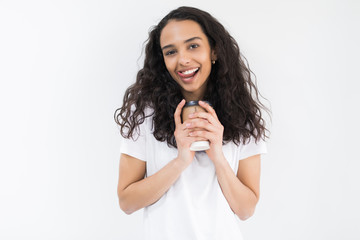 Portrait of smiling young woman holding laptop and cup of coffee isolated on a white background