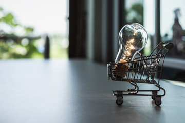 Light bulb with Shopping cart on a white background. Creative light bulb idea, power energy or...