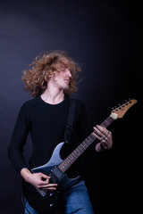 Obraz premium Young caucasian adult playing guitar in the studio