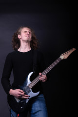 Obraz premium Young caucasian adult playing guitar in the studio