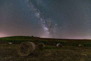 Vista notturna di un campo di balle di fieno con via lattea, Sicilia IT