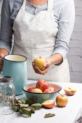 Woman in the kitchen washing a red apple