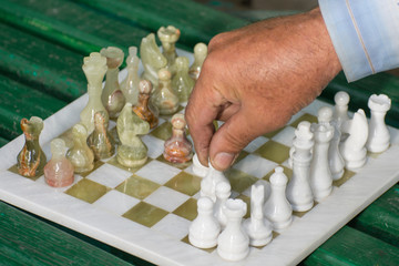 Chess game: the grandmaster makes a pawn move. Dedicated to International Chess Day.
