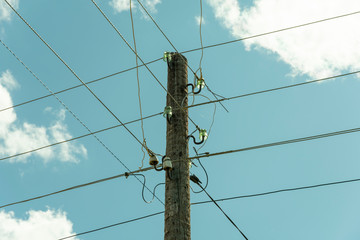 electricity network power pole with crossing wires and blue sky