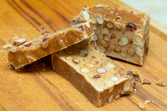 pieces of sorbet with peanuts, oriental sweets on a wooden kitchen board close-up