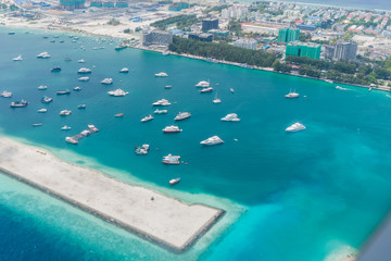 Scenery above the blue ocean from airplane window Maldives island
