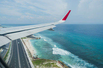 Fototapeta na wymiar Scenery above the blue ocean from airplane window Maldives island