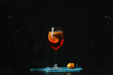 Bartender pours a sparkling wine with Aperol for Cocktails. Black background
