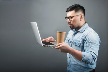a mature man holding a computer and coffee