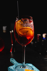 Red Wine glass with aperol spritz, italian alcoholic cocktail maked with aperol and sparkling wine, on dark background