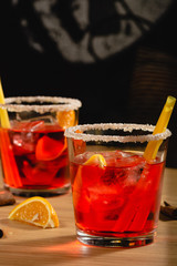 Red drink with ice, orange slices and sugar. Cocktail making bar tools