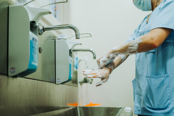 Unrecognizable doctor washing hands before operating
