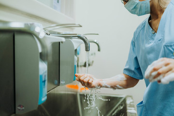 Unrecognizable doctor washing hands before operating