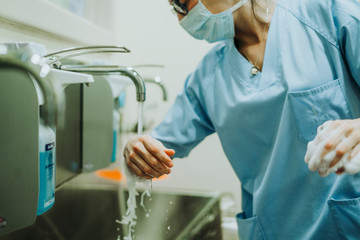 Unrecognizable doctor washing hands before operating