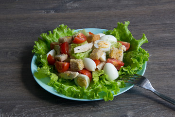 Salad with chicken, red tomatoes, eggs, cabbage, croutons and Caesar sauce