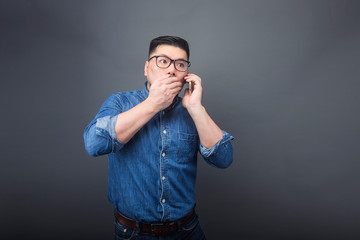A man is making a phone call with a surprised expression.
