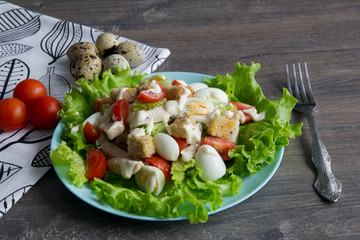 Salad with chicken, red tomatoes, eggs, cabbage, croutons and Caesar sauce