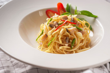 Salted fish spaghetti served in a white dish