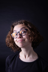 Young caucasian highschool girl with curly hair and round eyeglasses