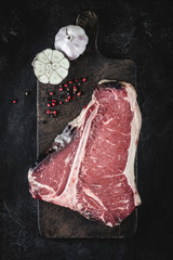 Premium Dry Aged Raw T-bone Steak on Rustic Kitchen Chopping Board - 276762662