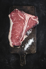 Dry Aged Beef Raw T-bone Steak on Vintage Cutting Board
