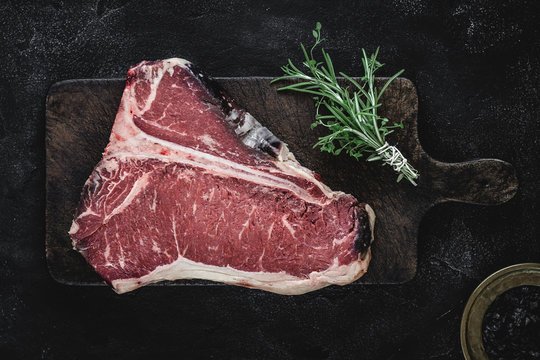 Dry Aged Beef Raw T-bone Steak on Vintage Cutting Board
