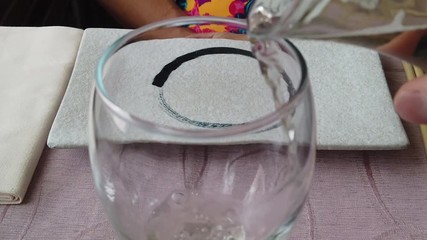 SLOW MOTION: Close up pouring sparkling white wine into a glass at dinner in a japanese sushi restaurant with slow-motion effect. - Powered by Adobe