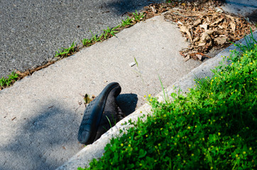 Single shoe in curbside debris