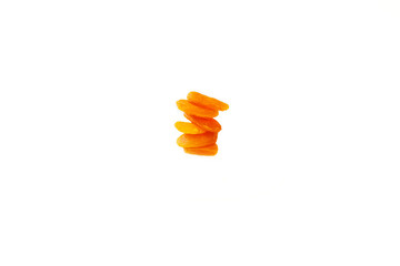 several pieces of dried apricots on a white background stacked in a tower