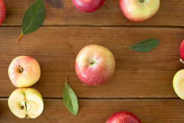 fruits, food and harvest concept - ripe red apples on wooden table